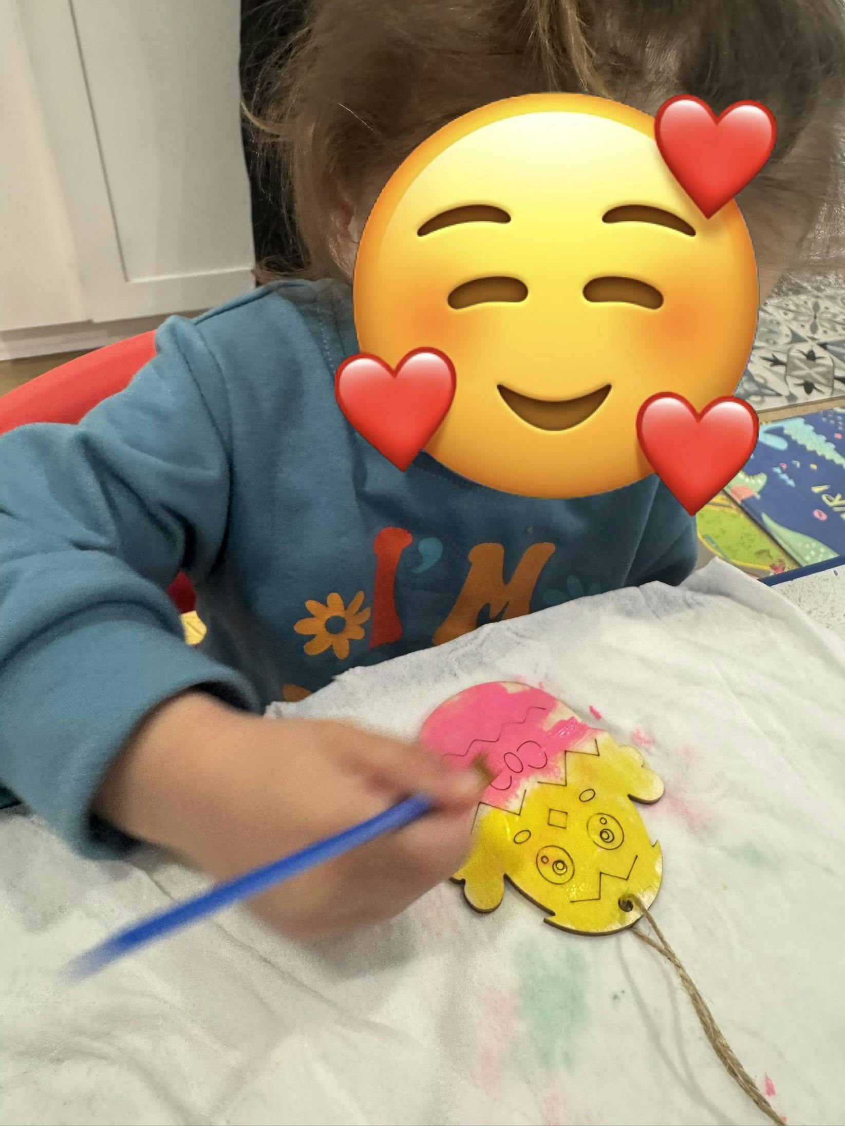 Child painting a cracked egg-shaped cutout