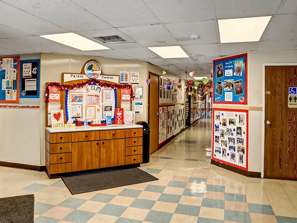 Hallway with bulletin boards, cabinets, and heart decorations