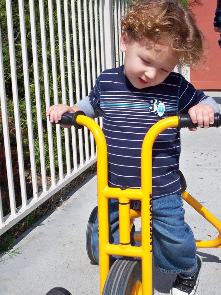 Child on a yellow tricycle