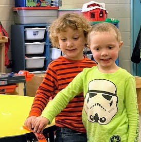 Two children standing together in a room