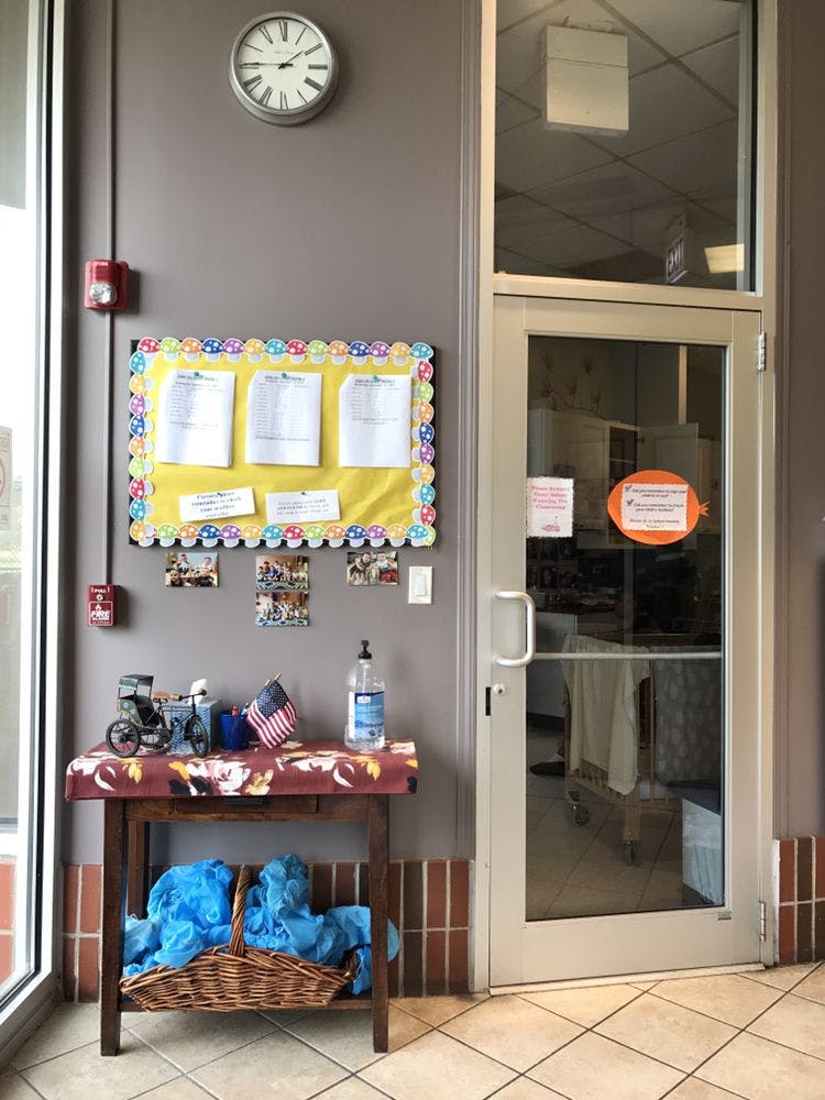 Bulletin board with papers, table with American flag, and glass door