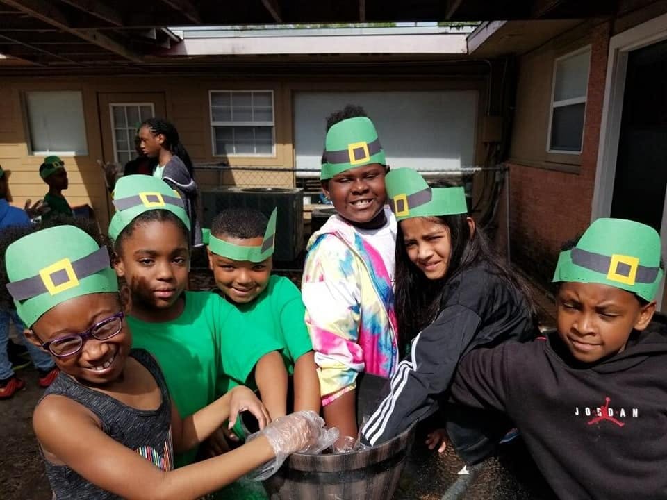 Group of children wearing green hats with buckles