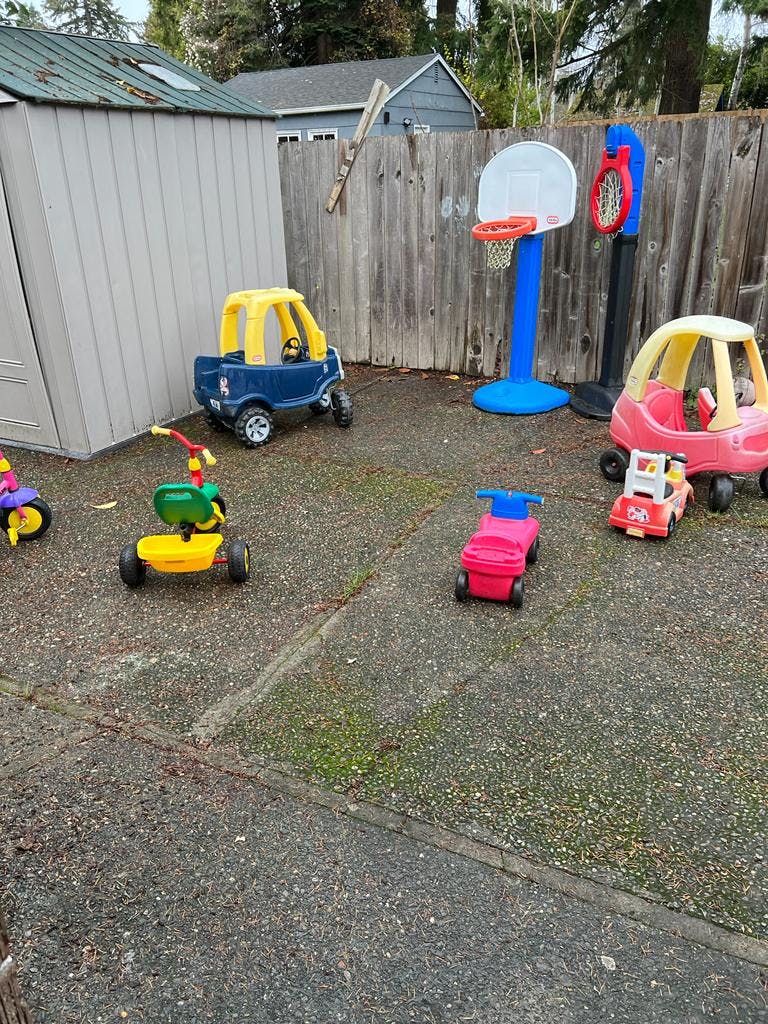 Children's ride-on toys and basketball hoops in a yard