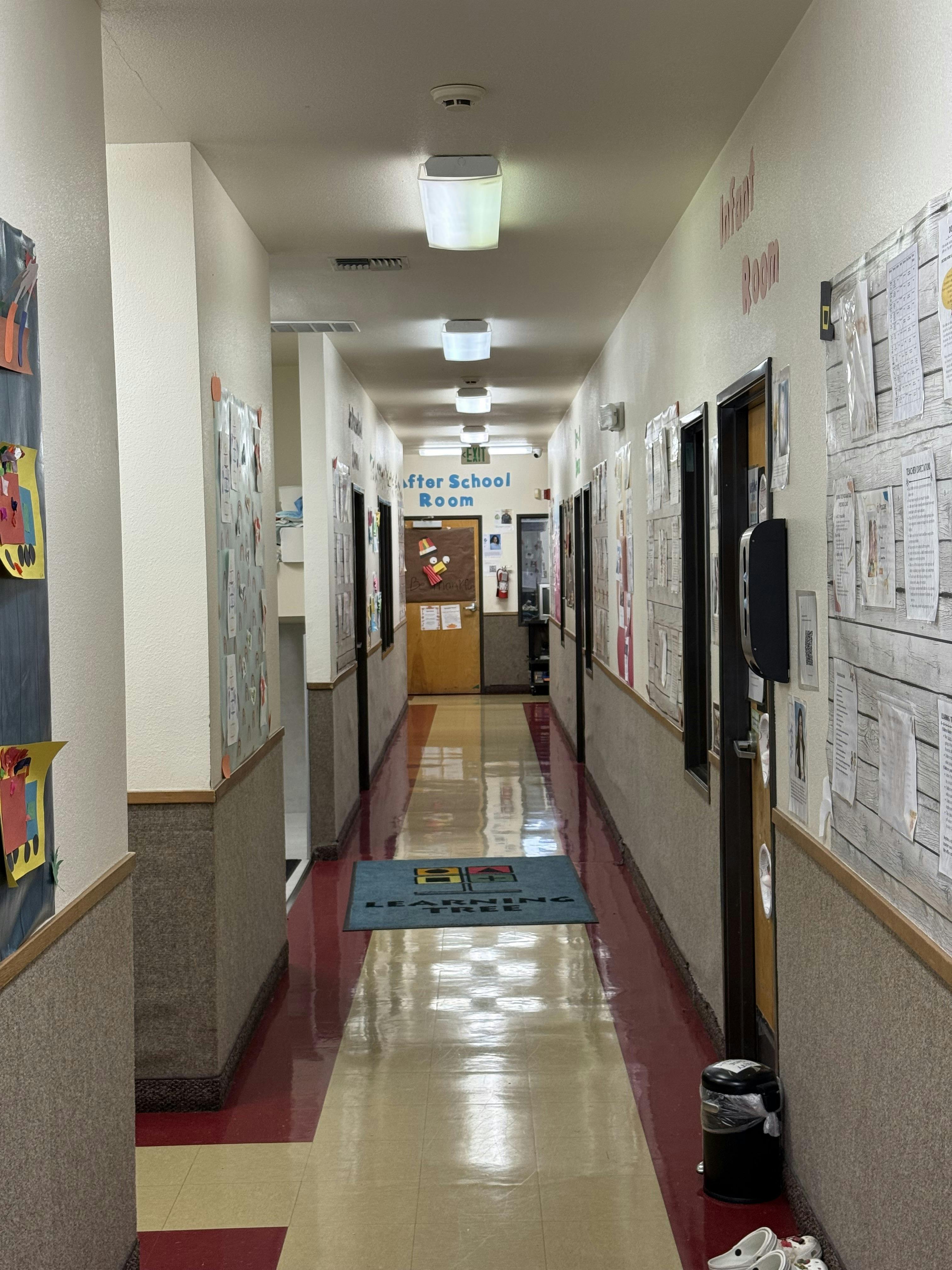 Long school hallway with doors and papers on the walls