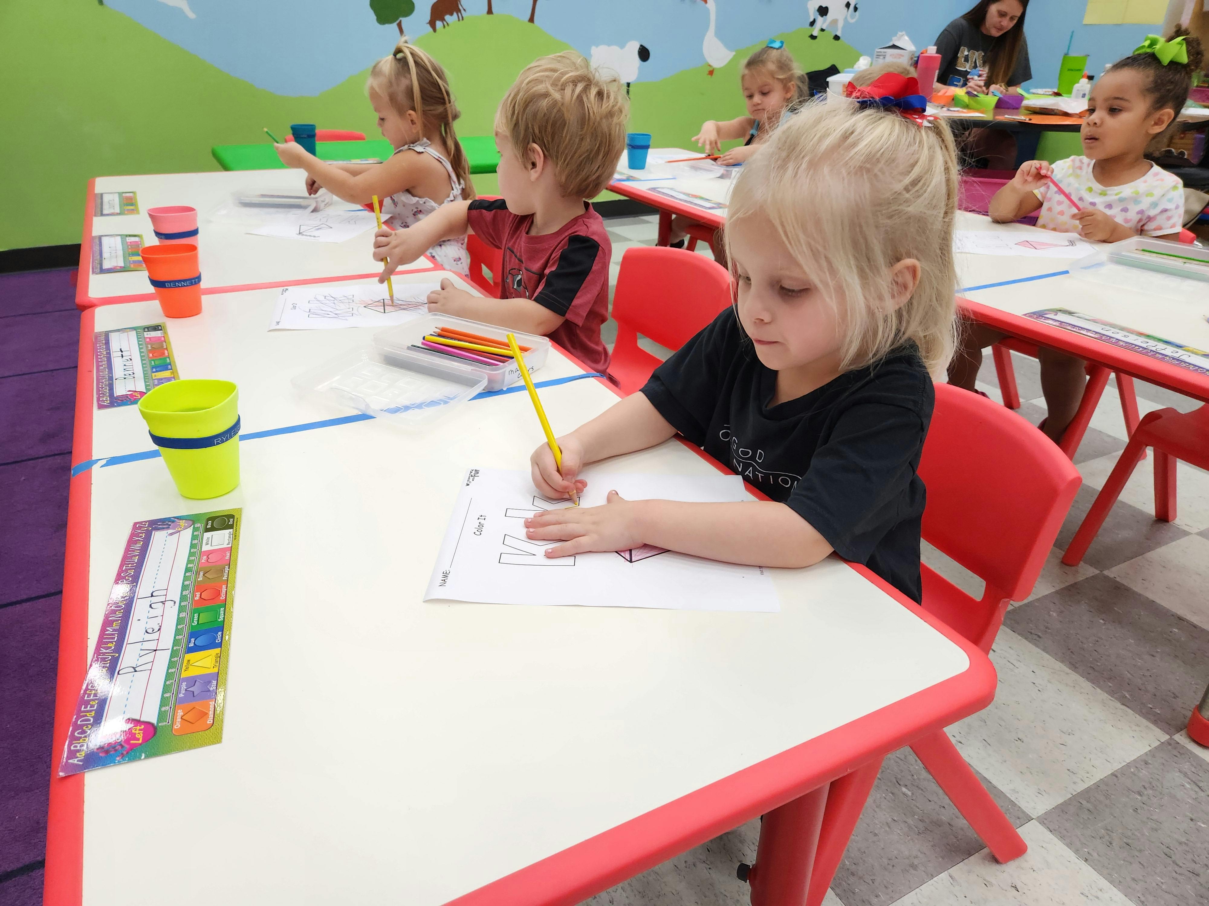 Children drawing at tables in a classroom