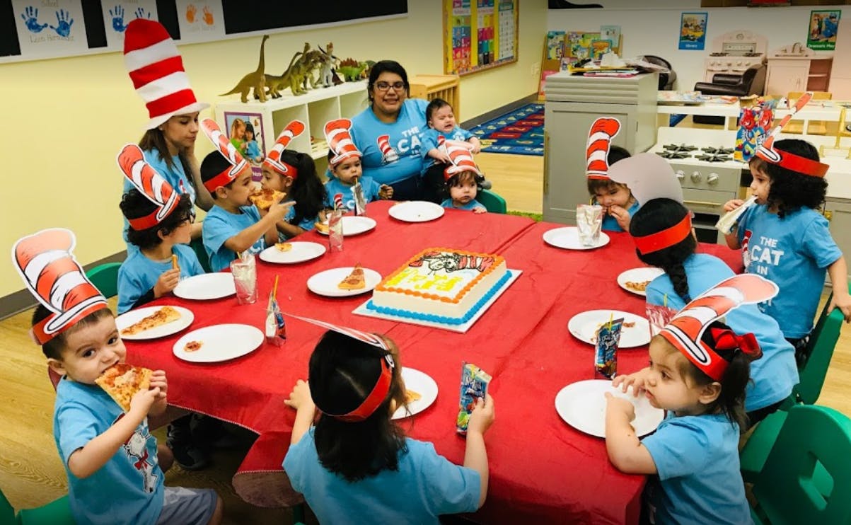 Children and adults at a table with a cake