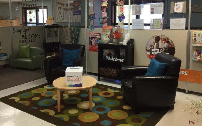 Lounge area with three chairs, coffee table, and a 'Share your gratitude' box