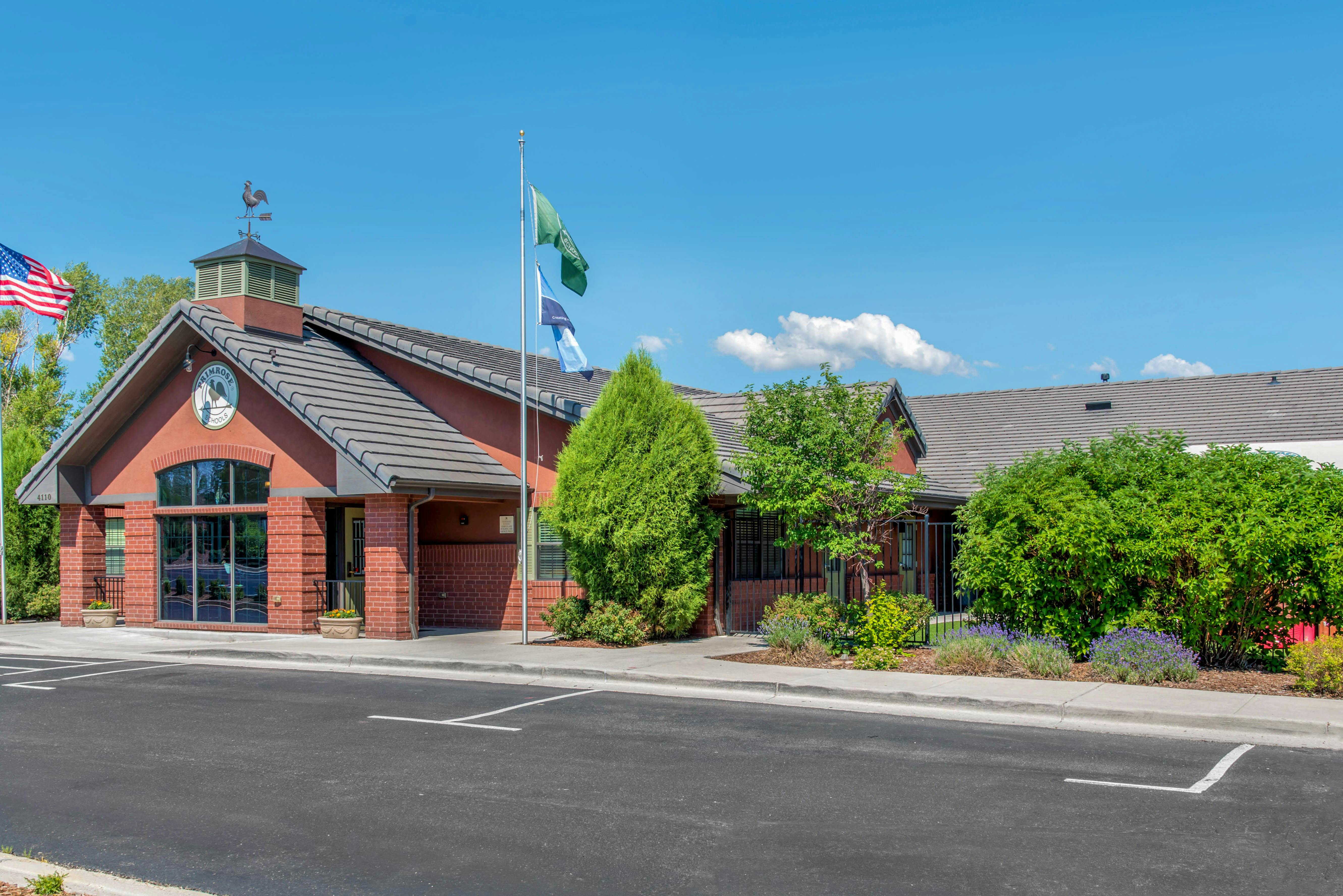 Primrose School building exterior with a US flag and school flags