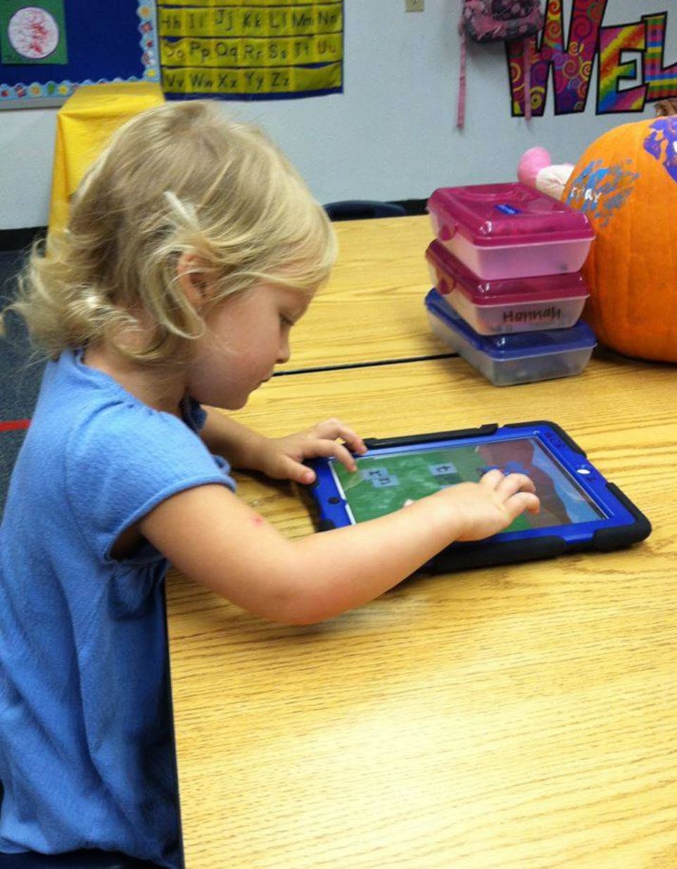 Child using a tablet at a table