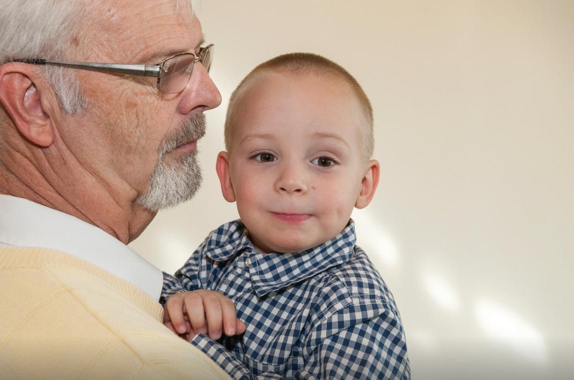 Adult holding a child in a plaid shirt