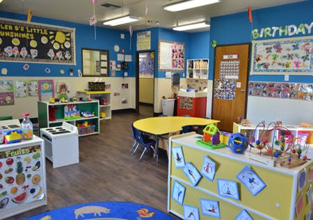 Preschool classroom with tables, chairs, and learning materials