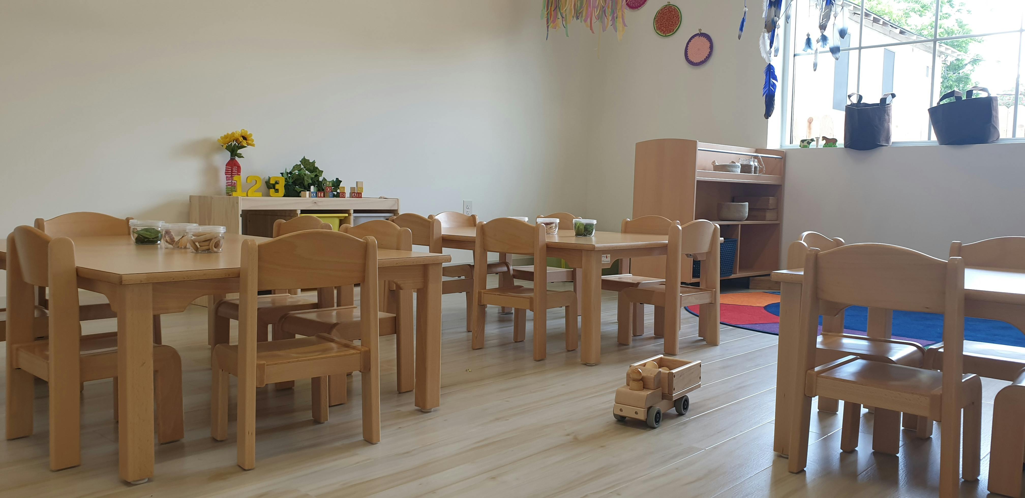 Classroom with small wooden tables and chairs