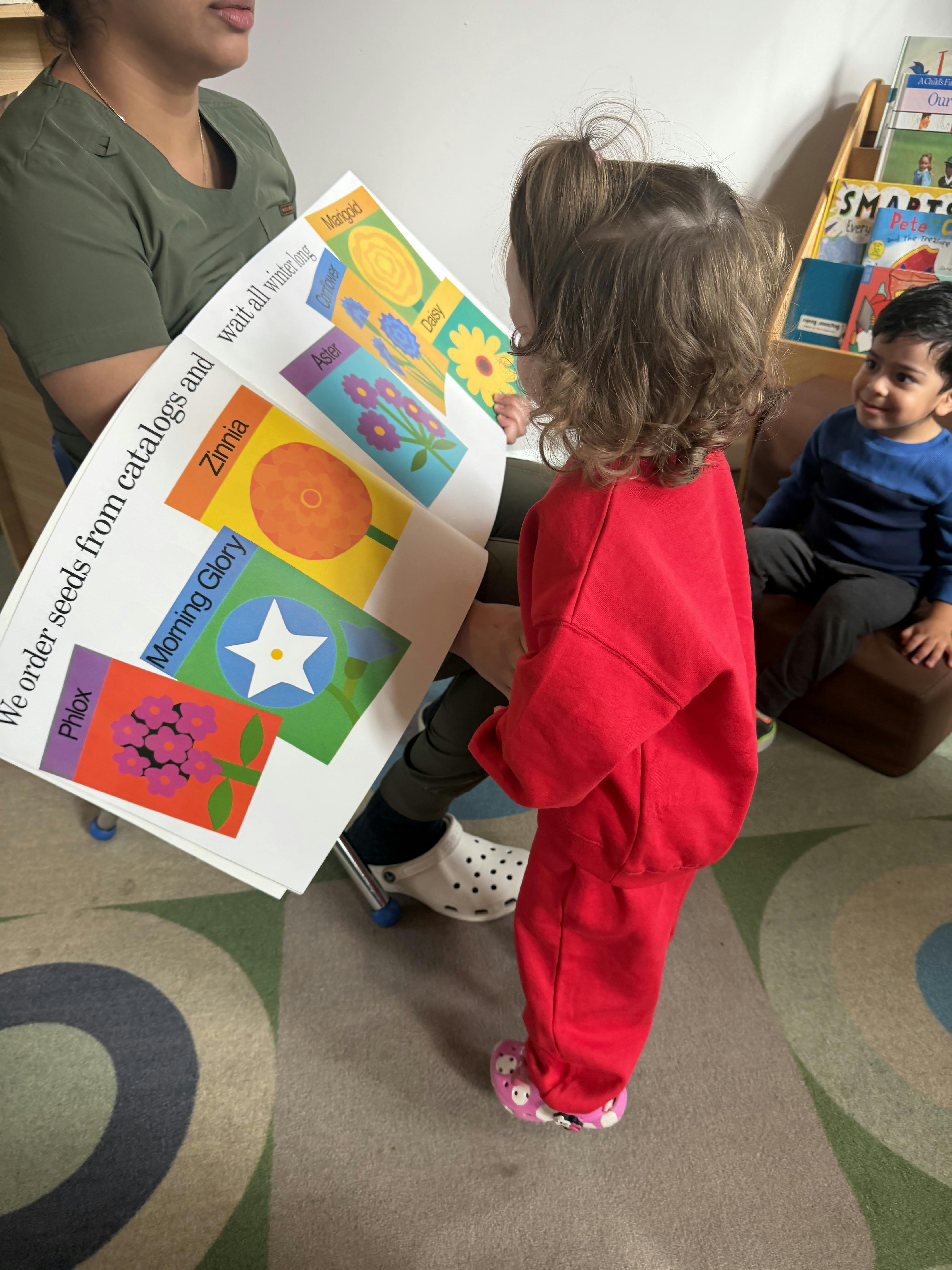 A person reading a book about flowers to a child