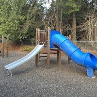 Playground with a blue tube slide and a silver open slide