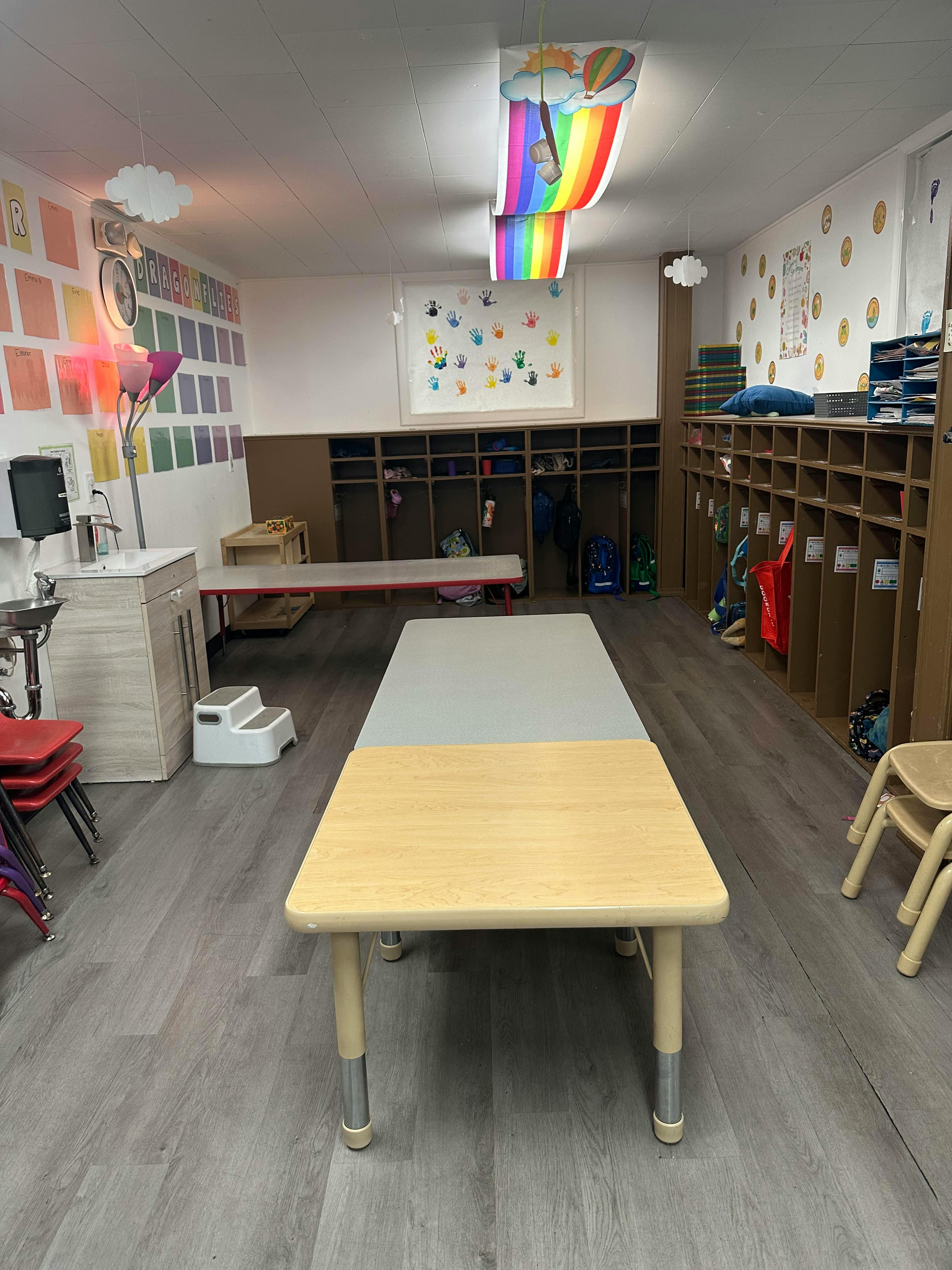 Classroom with tables, cubbies, and a sink