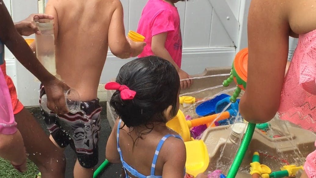 Children playing with water table toys