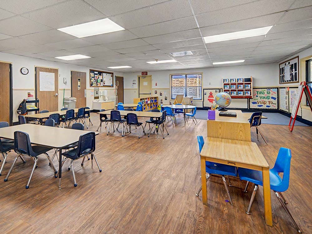 Empty classroom with small tables and chairs
