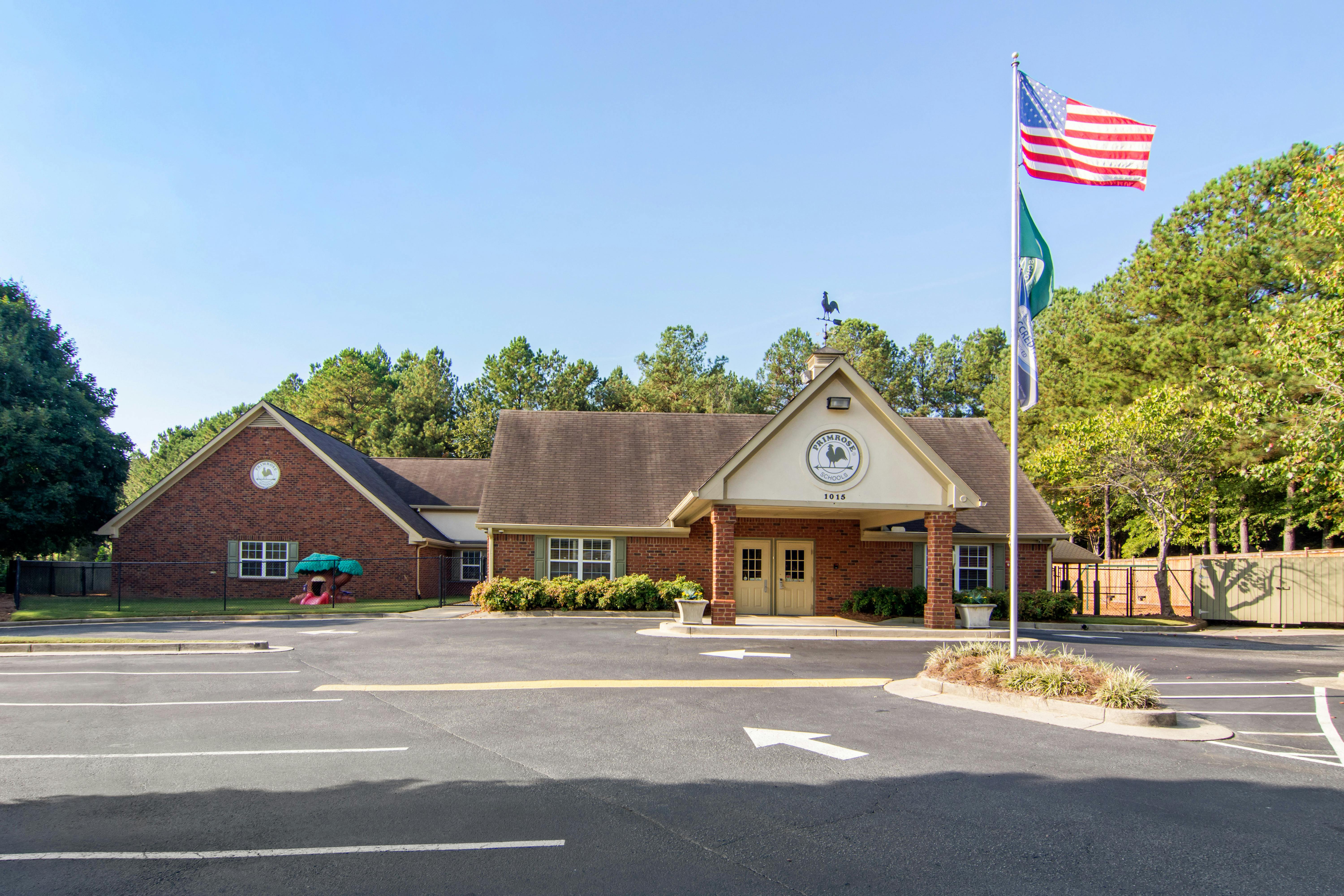 Primrose School building with a parking lot and an American flag flying