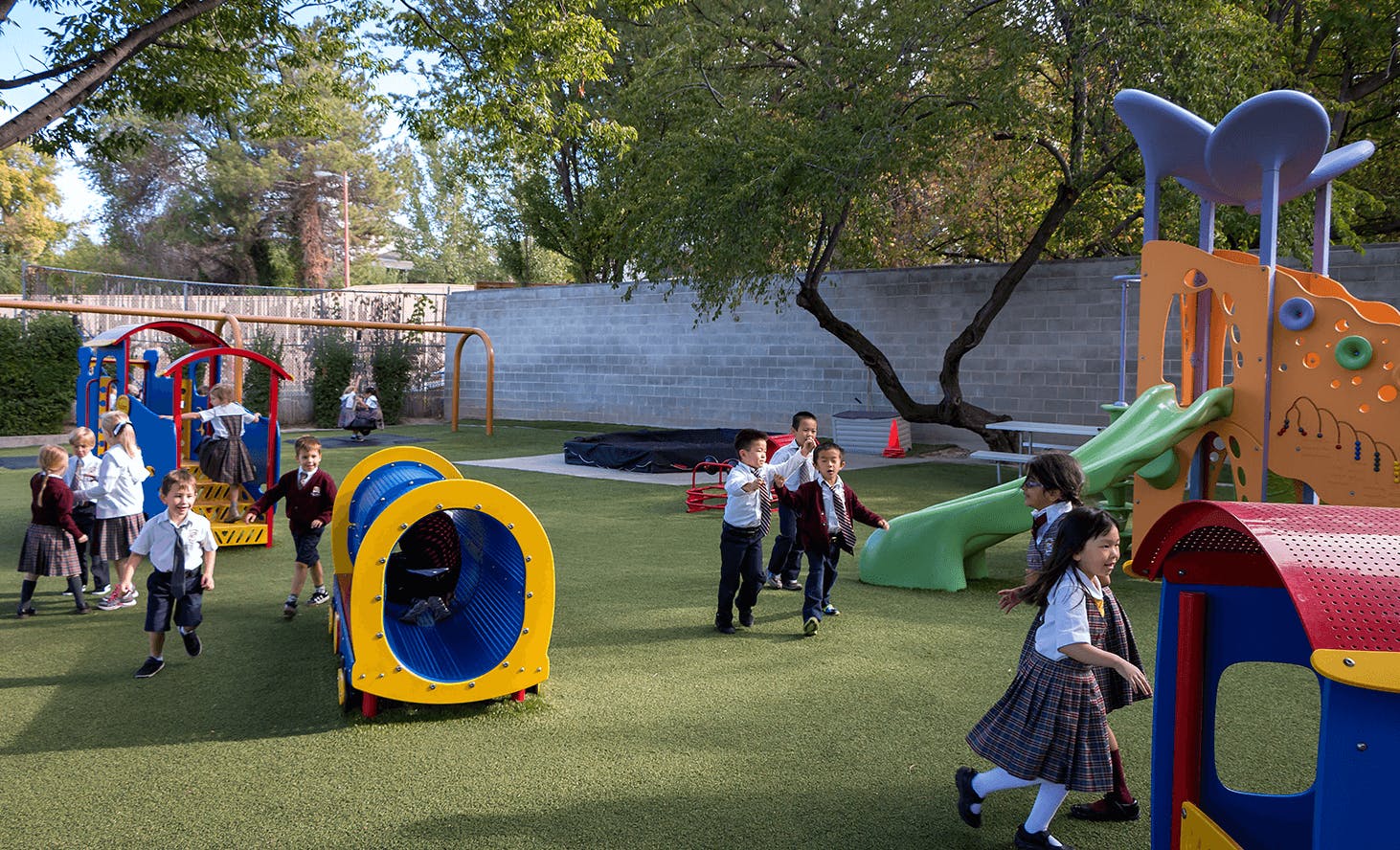 Children playing on a playground with tunnels and slides