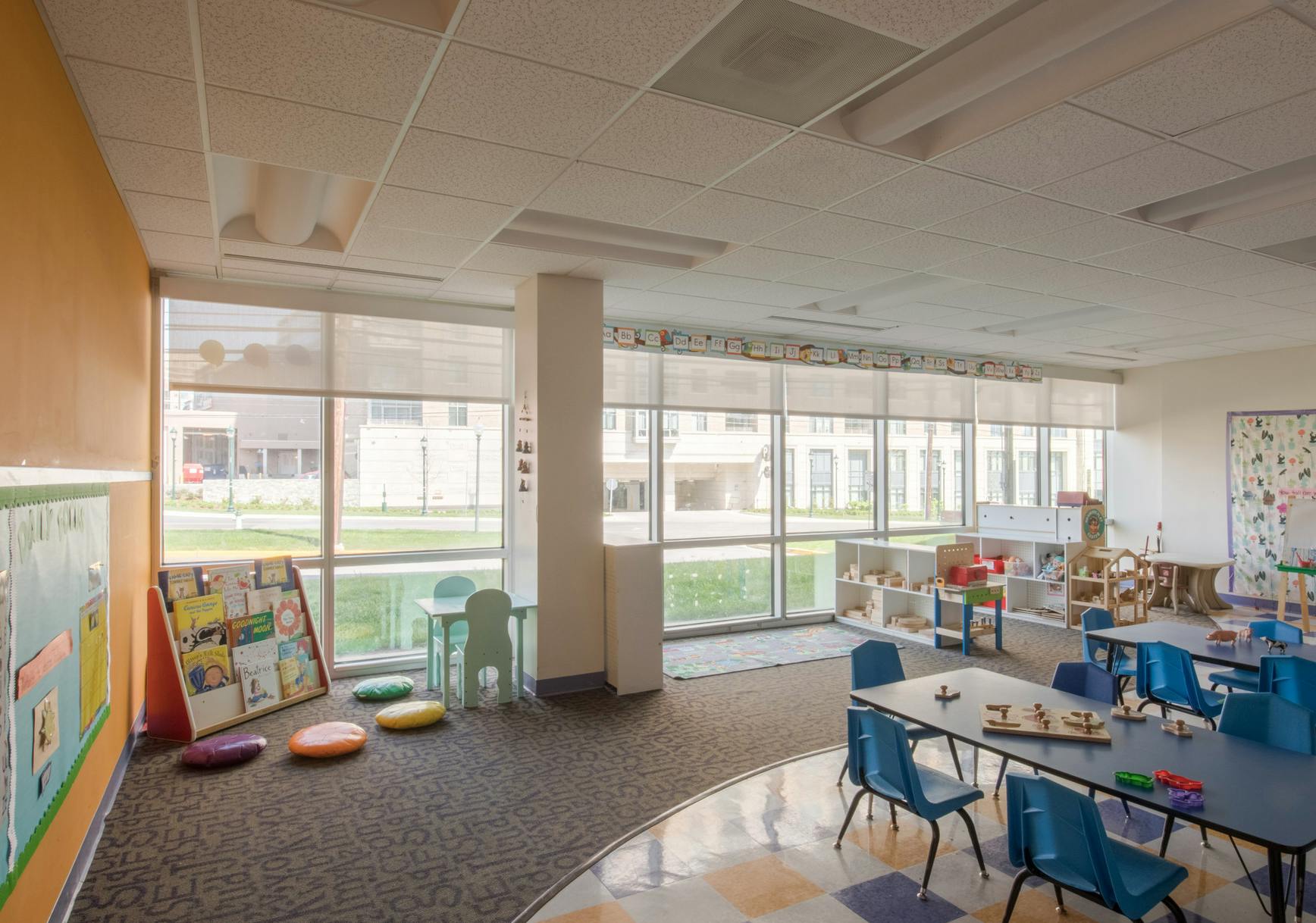 Empty classroom with tables, chairs, and large windows