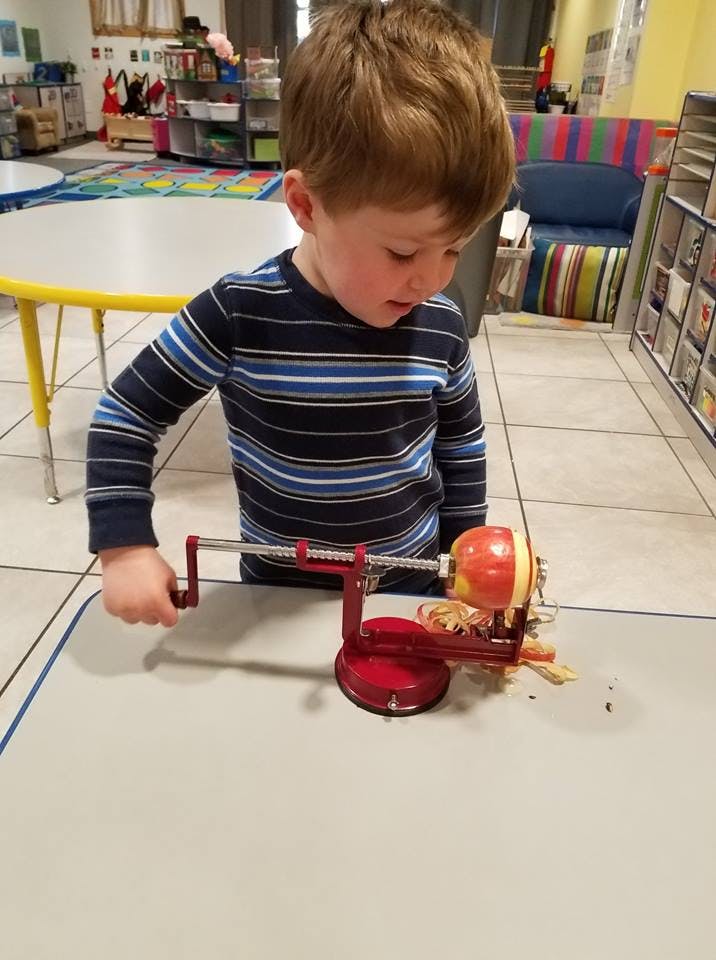 Child using an apple peeler