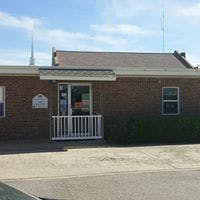 Brick building with a white railing at the entrance