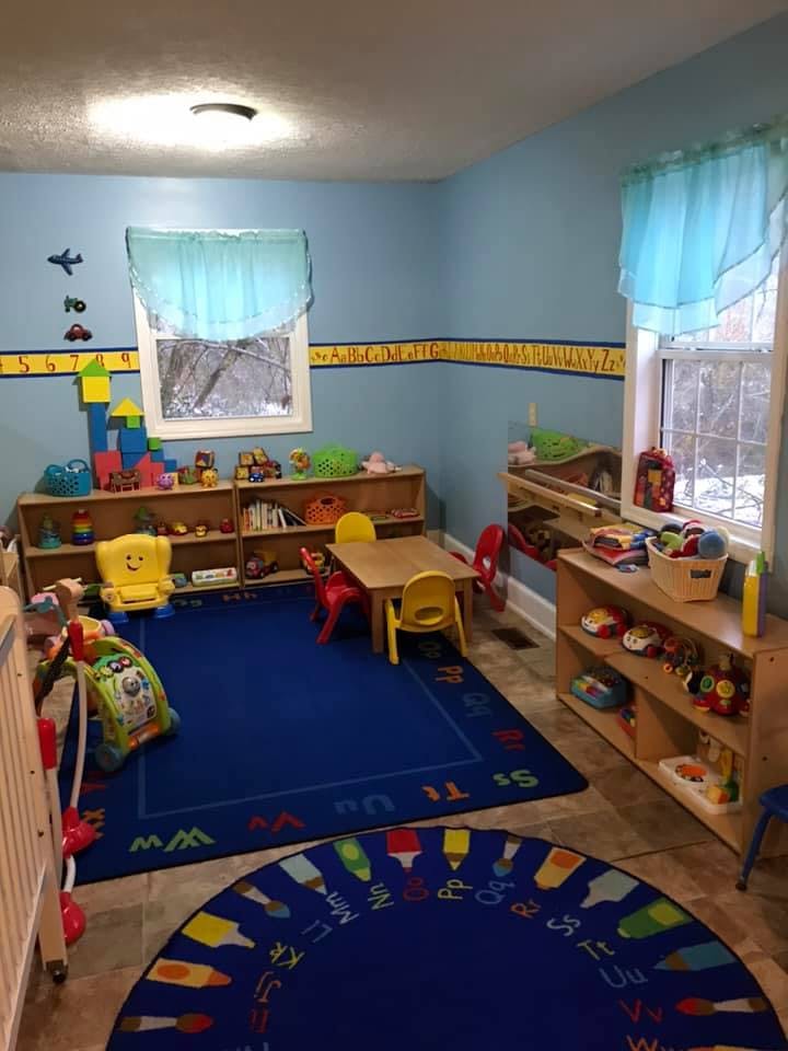 Playroom with blue walls, two windows, and various toys and furniture