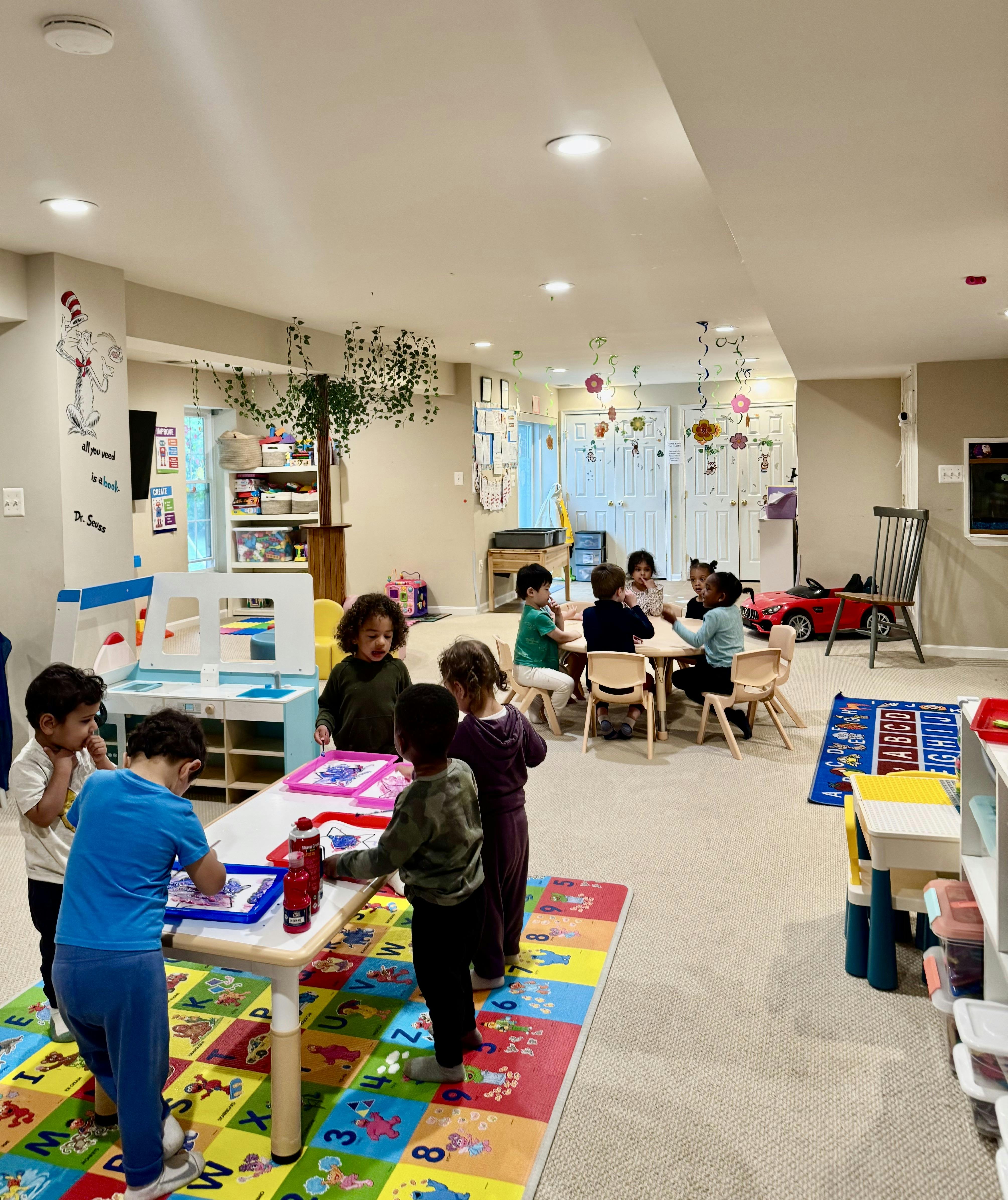 Children painting at tables in a playroom