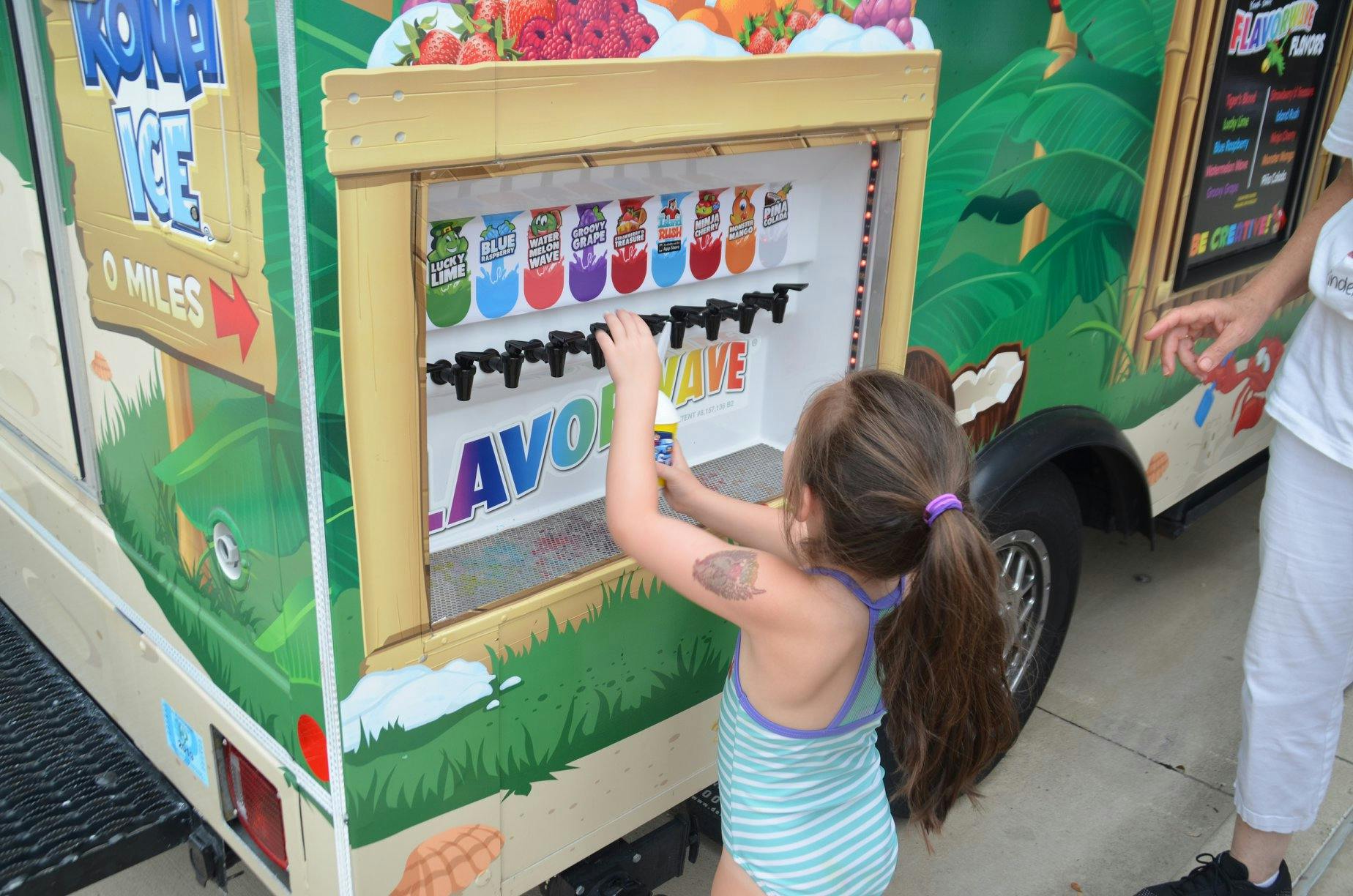 Child dispensing a drink from a colorful beverage truck