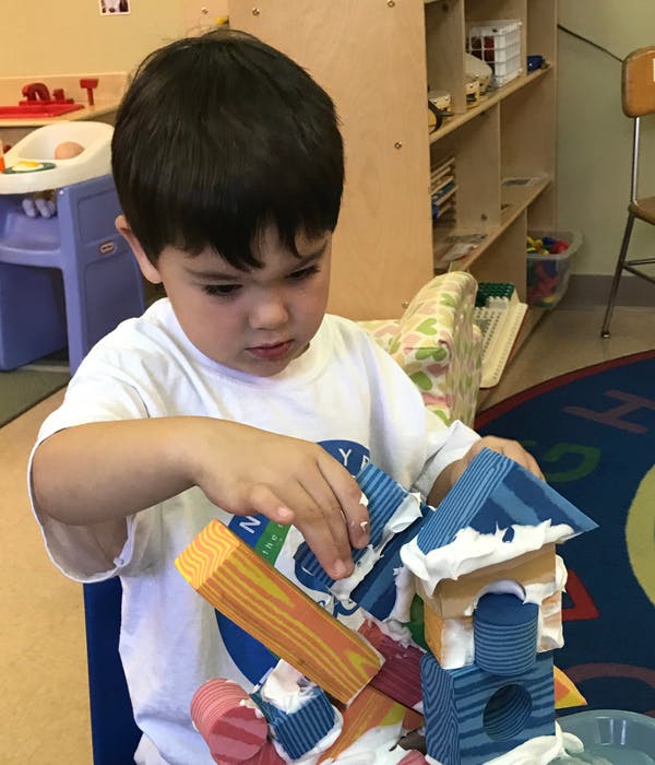 Child playing with building blocks in a classroom