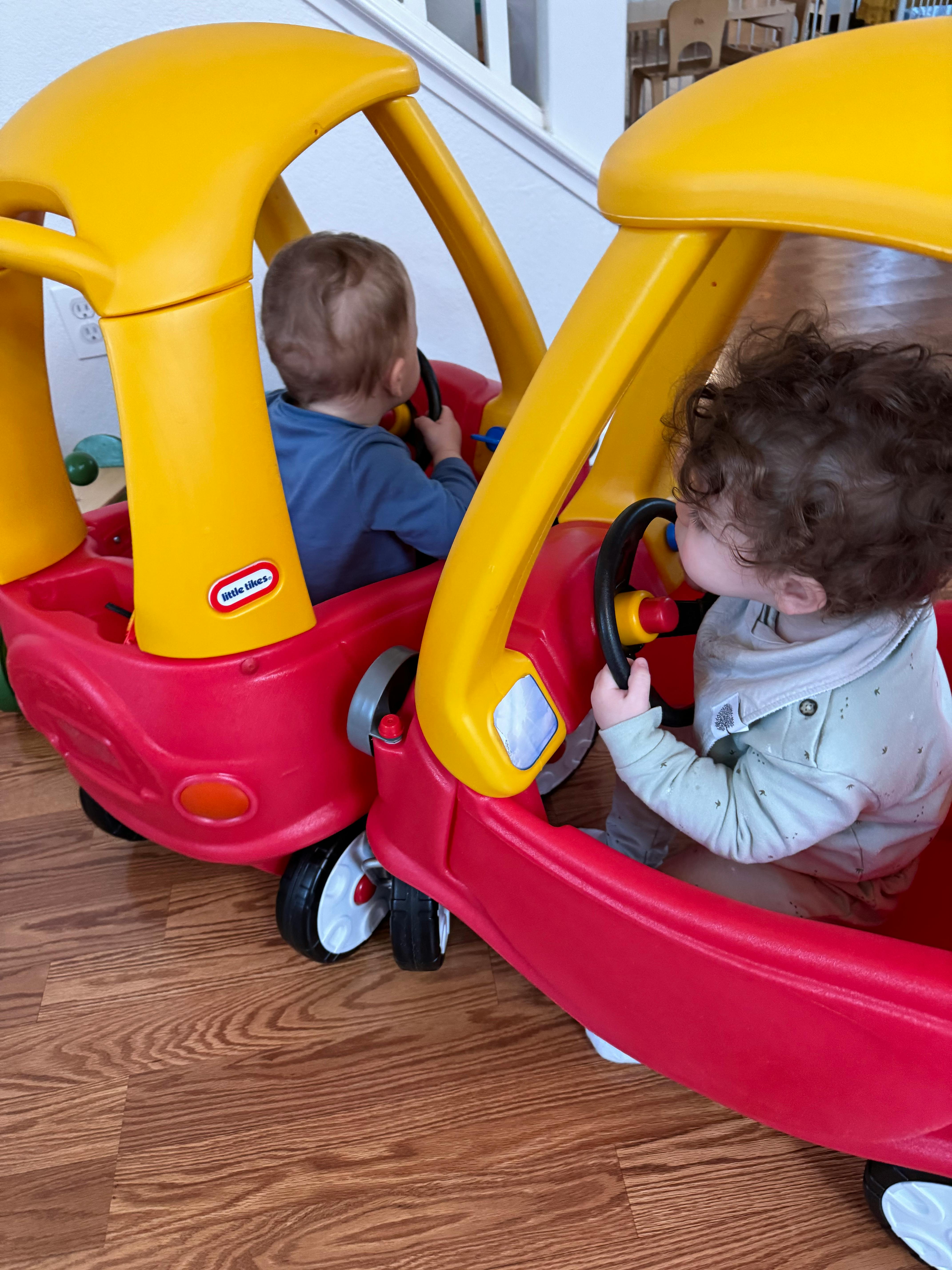 Two children in toy cars