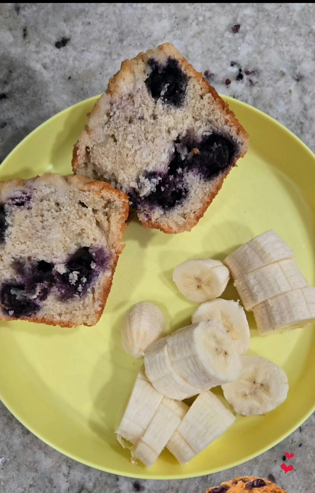 two blueberry muffin halves and sliced bananas on a plate
