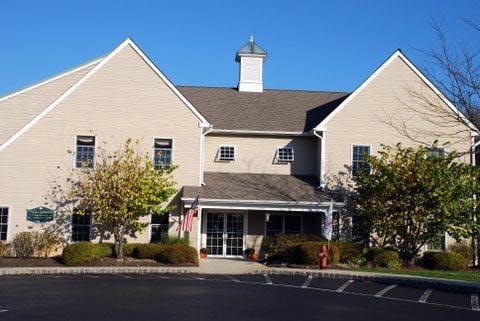 Large building with light-colored siding and a cupola