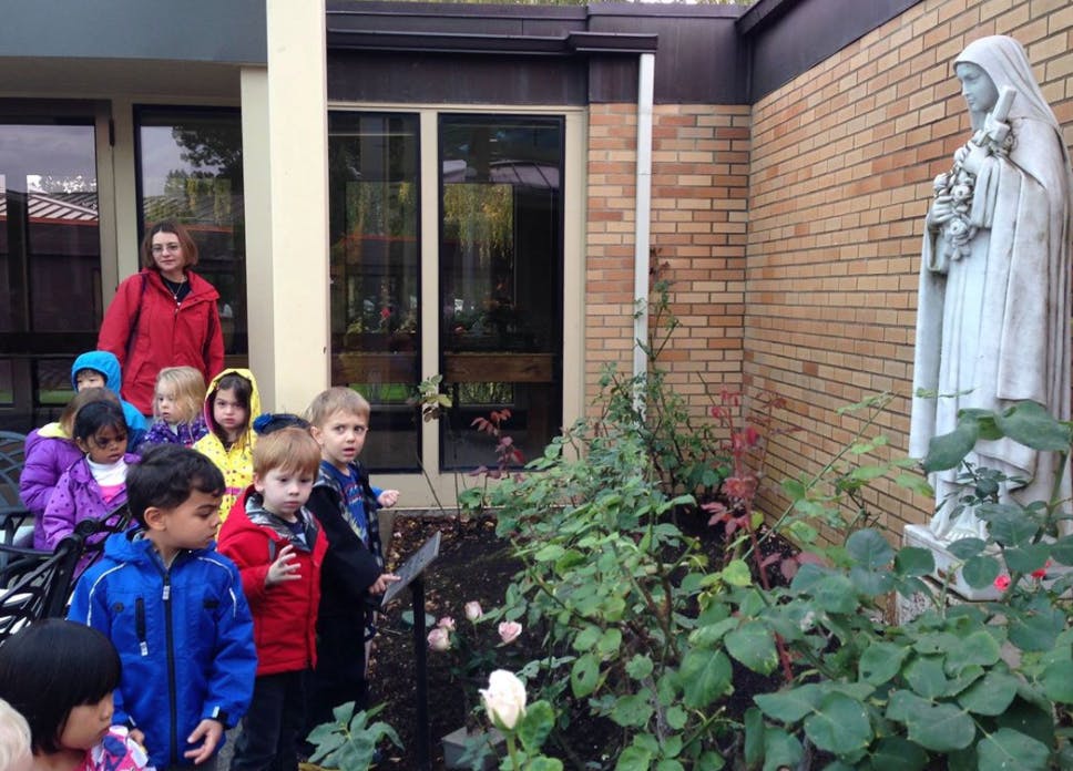 Adult and children looking at a statue in a garden