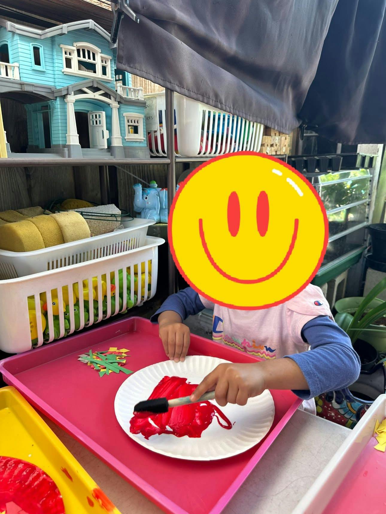Child painting on a paper plate with a brush