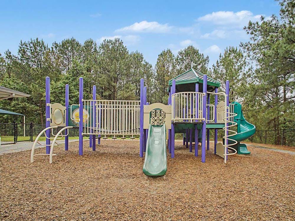 Colorful playground structure with slides and climbing areas on wood chips