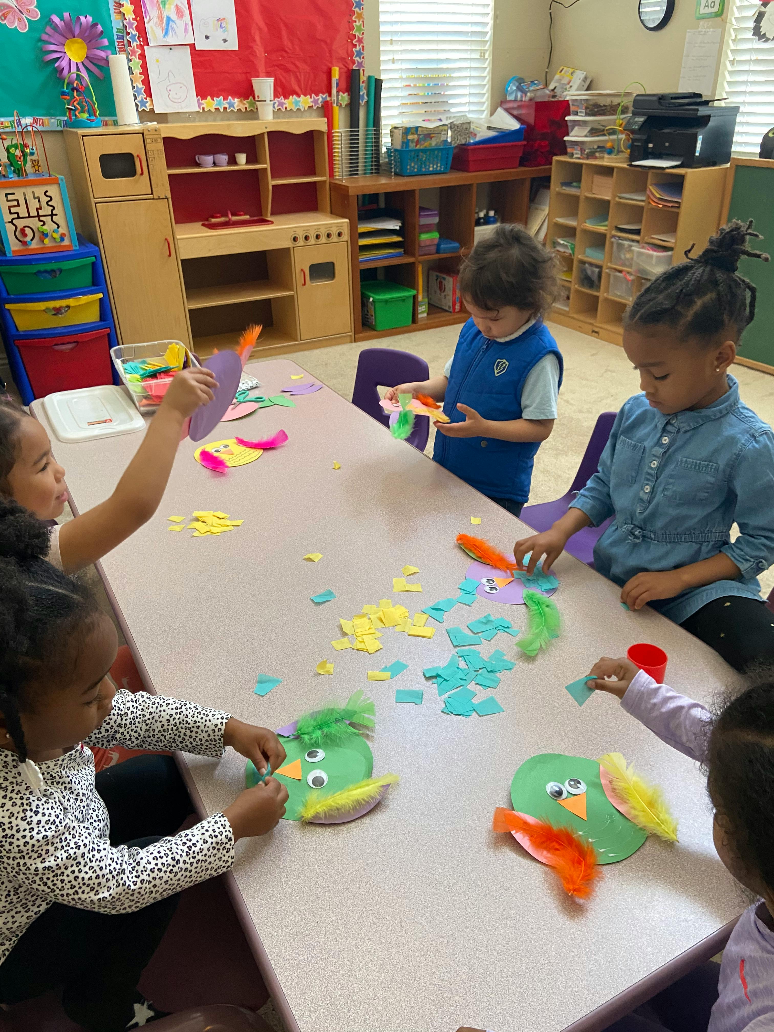 Children making crafts at a table in a classroom
