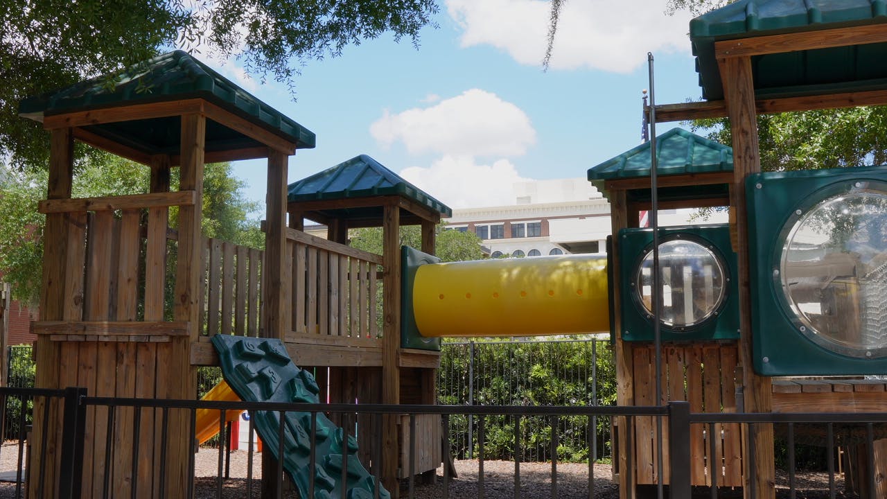 Wooden playground structure with a yellow tunnel slide