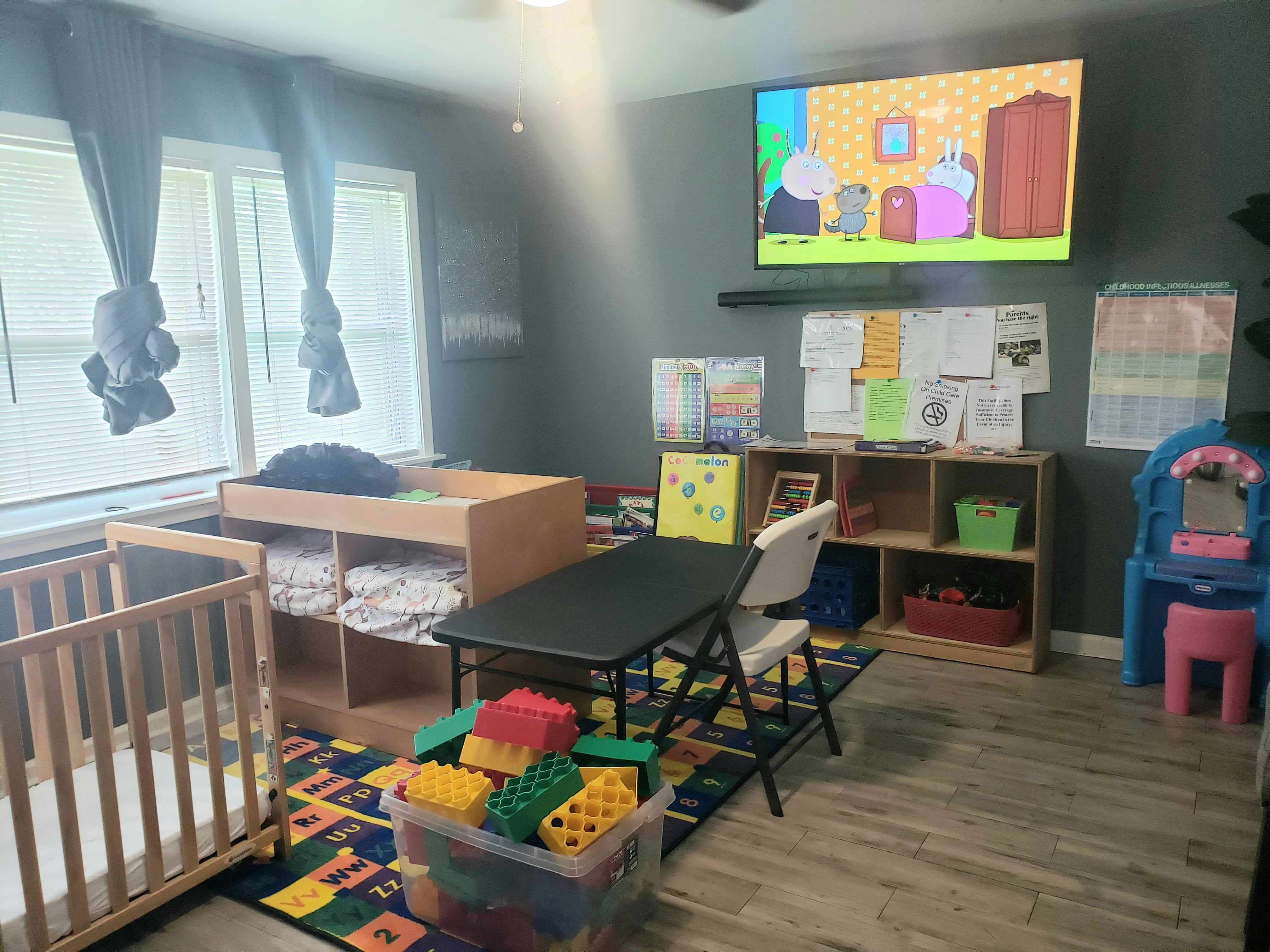 Child's room with crib, changing table, play table, and television