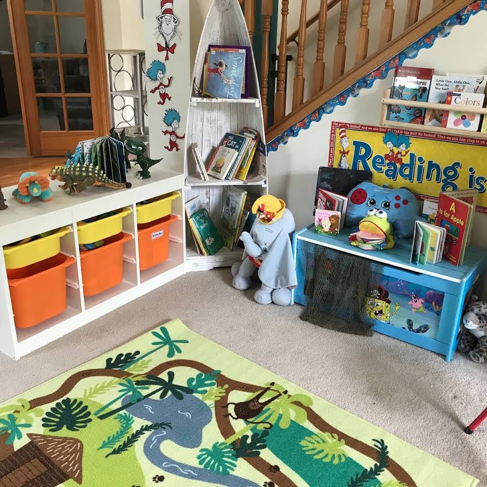 Children's play area with toy storage, bookshelves, and a colorful rug