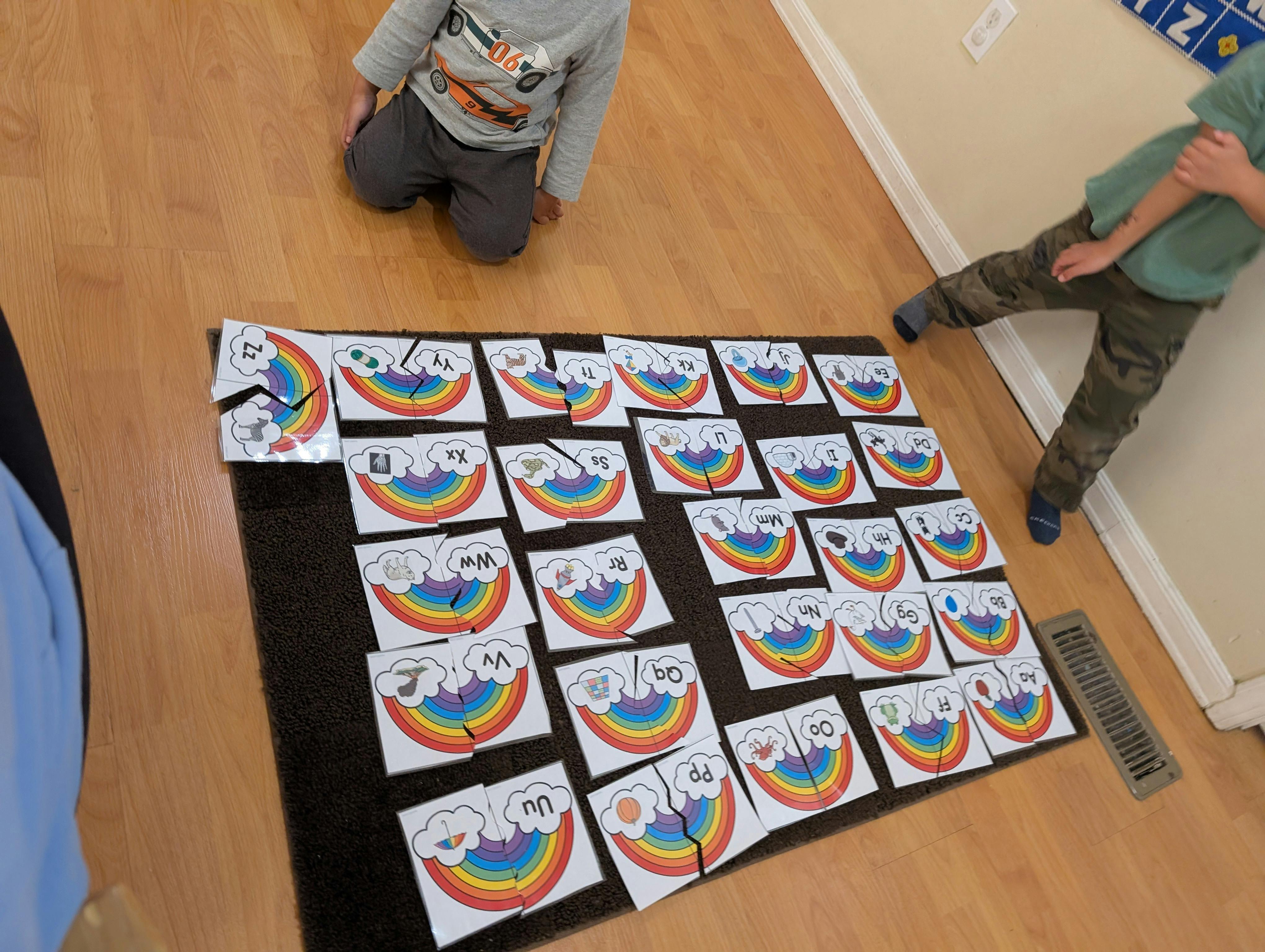 Two children with rainbow puzzle pieces on the floor
