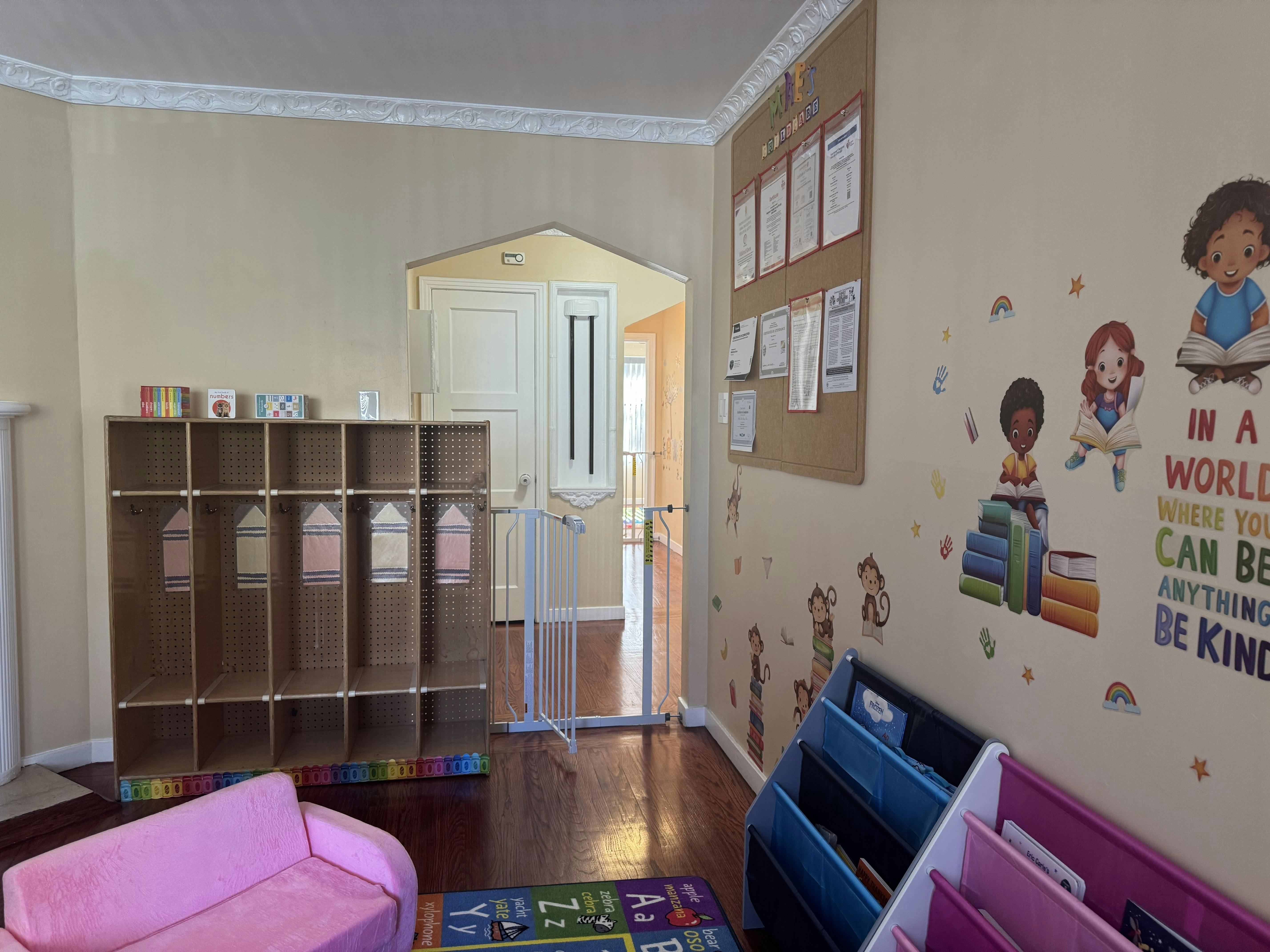 Child's playroom with a pink couch, cubbies, and wall decals