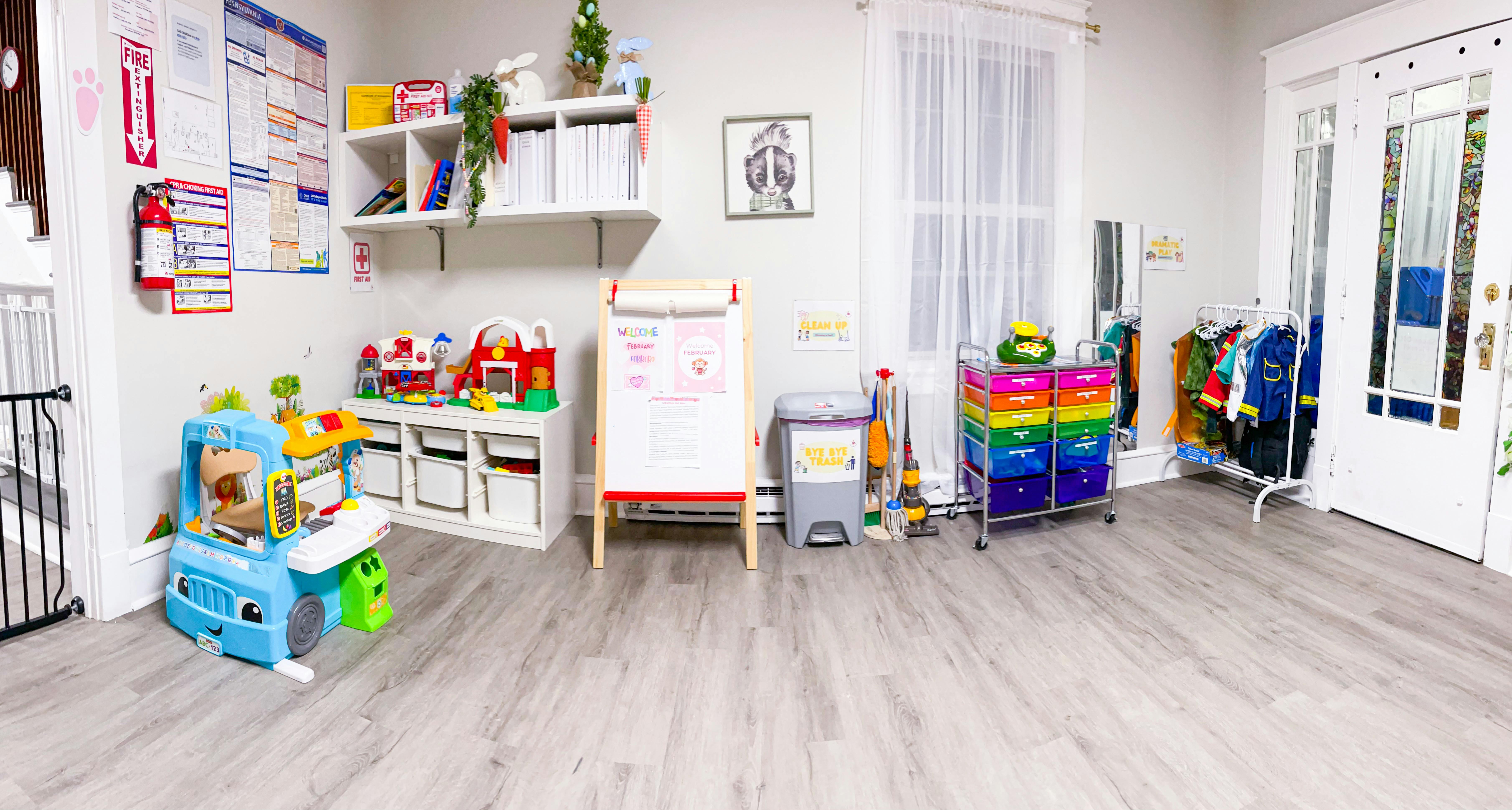 Playroom with toys, storage bins, an easel, and a rolling cart