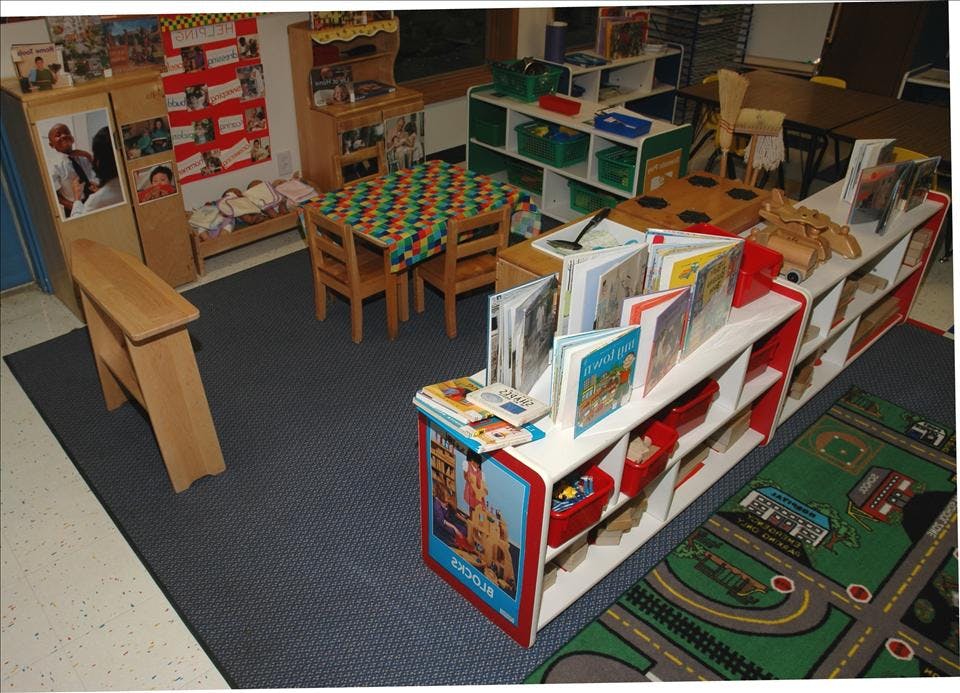 Classroom with child-sized tables, chairs, bookshelves, and various learning materials