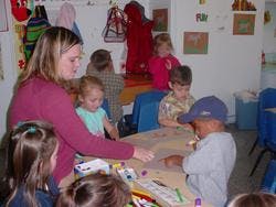 Adult and children at a table in a classroom