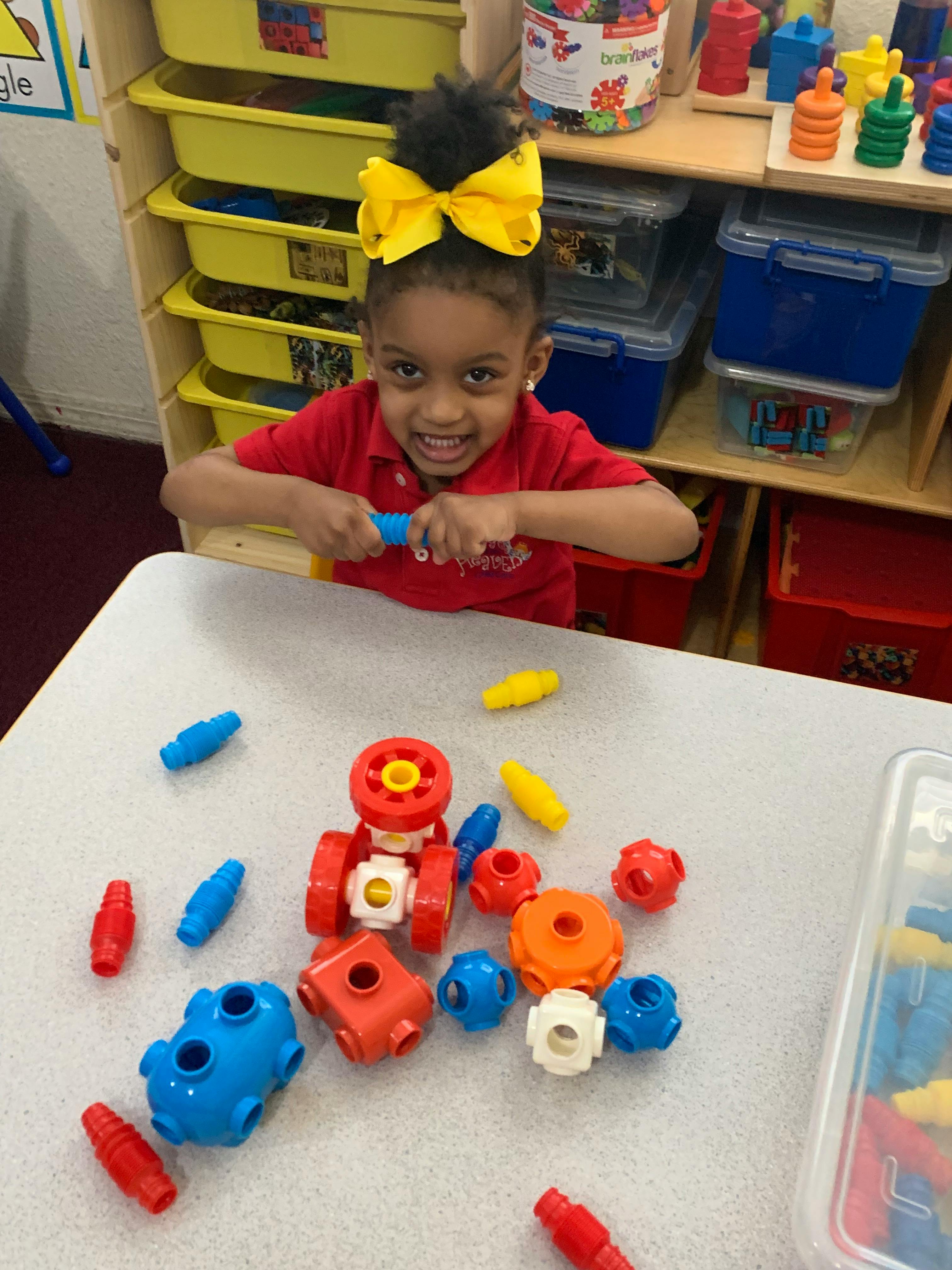 Child playing with colorful building toys at a table