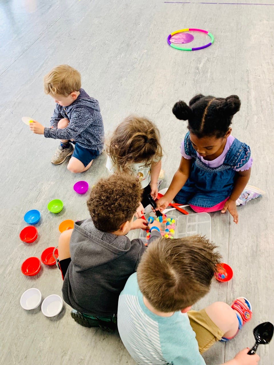 Children playing with colorful bowls and toys on the floor