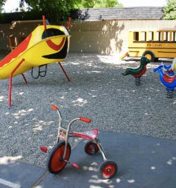 Tricycle and playground equipment on a sunny day