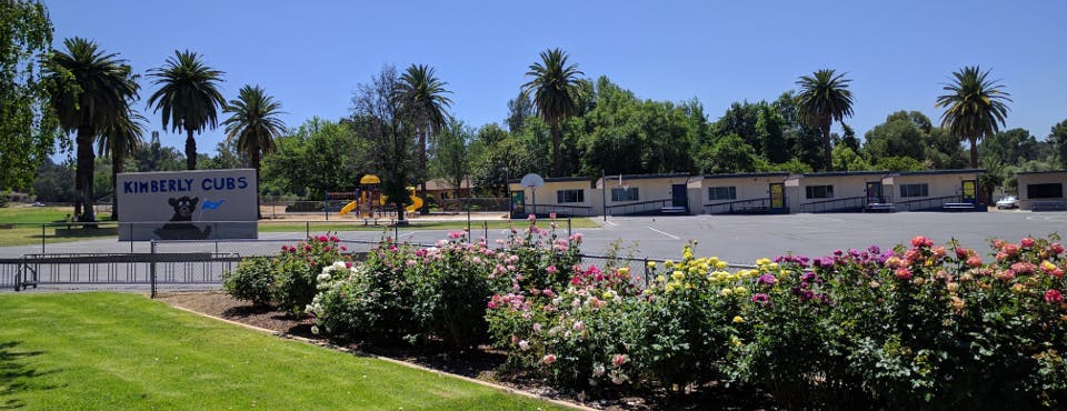Sign for "Sweetser Club" with buildings and palm trees in background