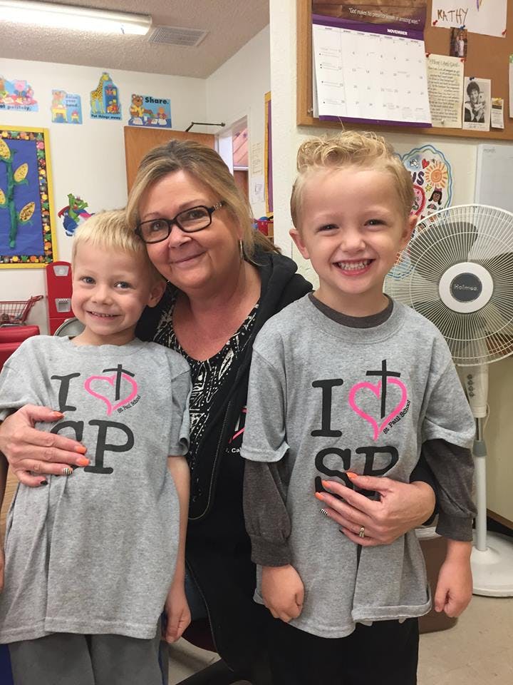 Adult person with two children in a classroom
